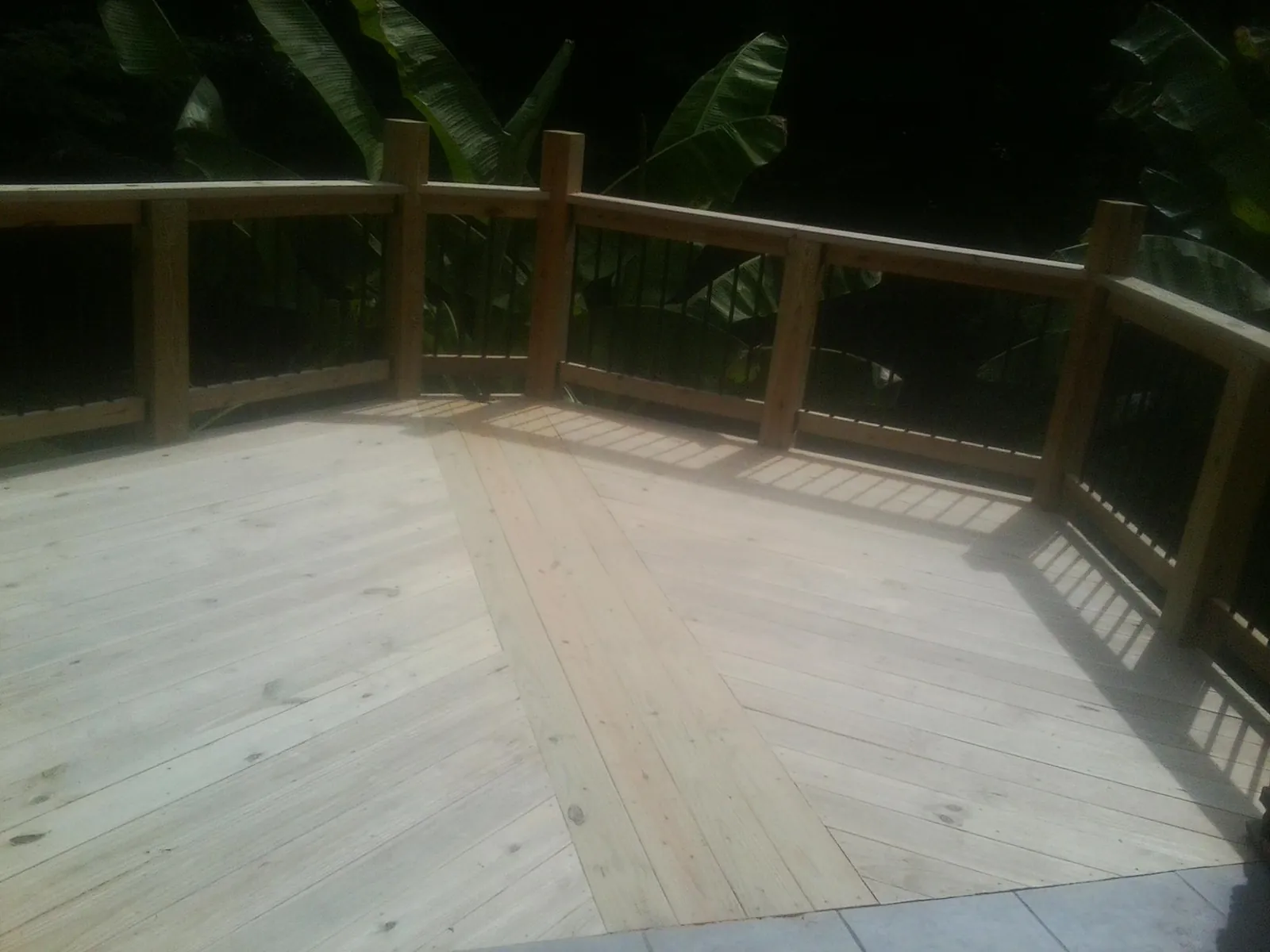 New wood deck and railing built off the back of a home in Gable