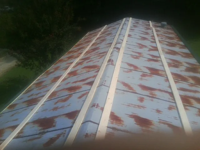 Rusted metal roof panels with new wood purlins before replacement — Storm Damage Roof Repair in Gable by Roofing Brothers